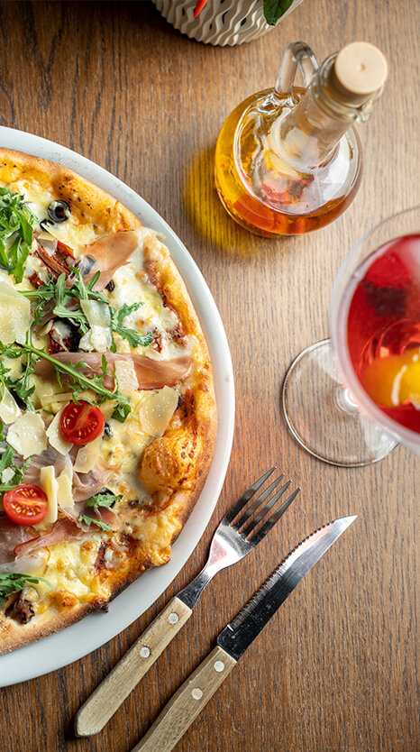 Pizza s paradajkovým základom a mozzarellou na tanieri na drevenom stole